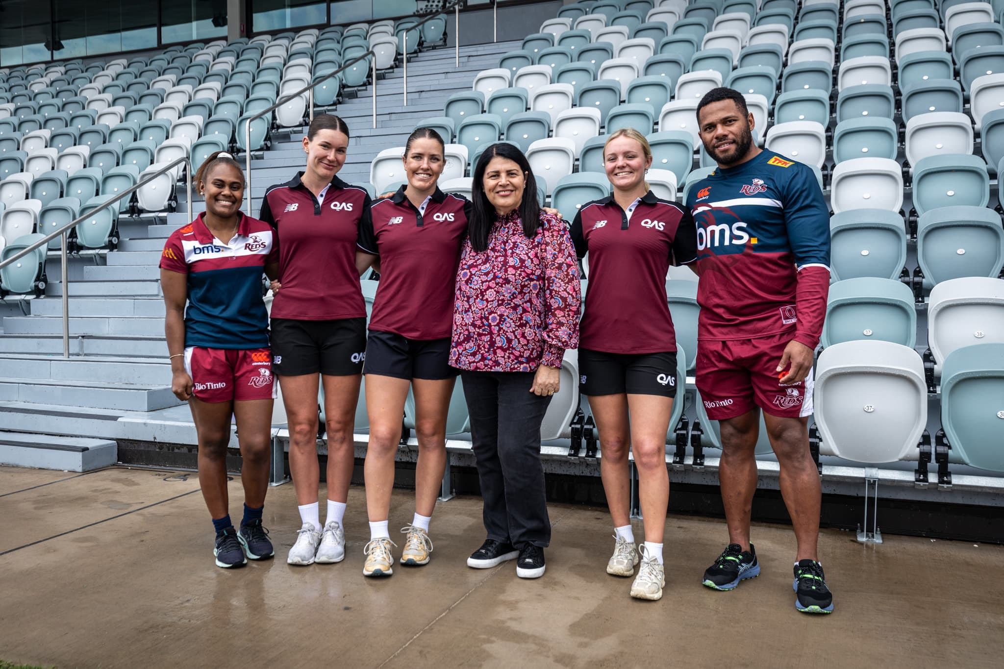 Minister Grace Grace with (from left)...Reds women Ivania Wong, Tahli Devine, Kahli Henwood and Piper Flynn plus Queensland's Wallaby Filipo Daugunu at today's Ballymore announcement.