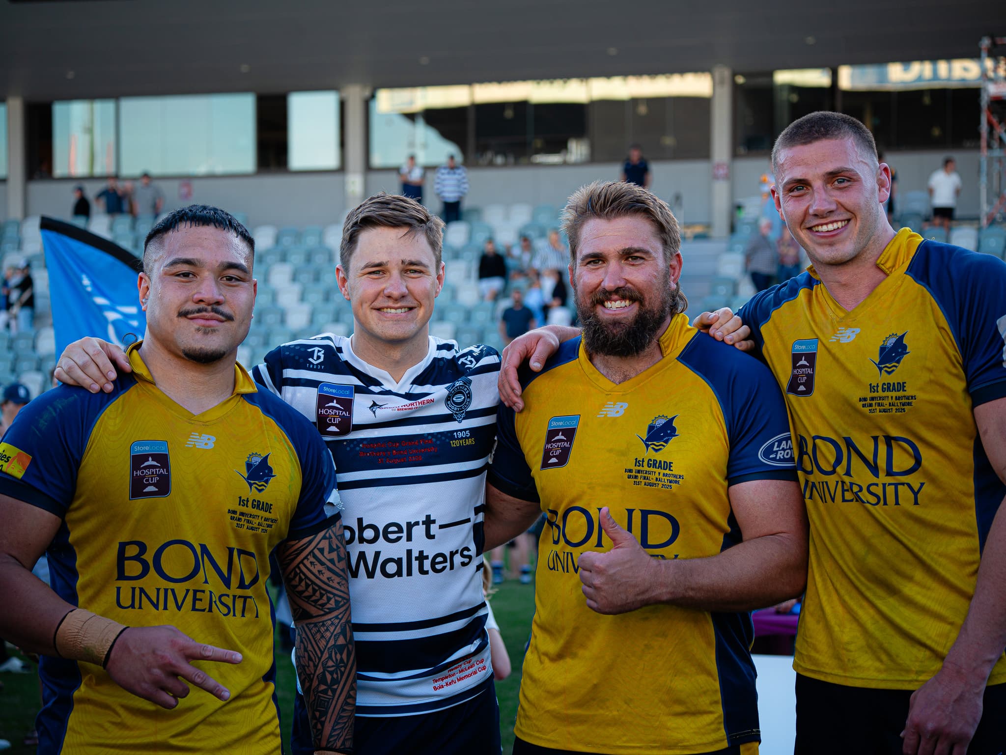 Reds at Bond University (from left) George Blake, Aidan Ross and Josh Canham celebrate while Brothers centre Josh Flook tries to hide the sting of grand final defeat