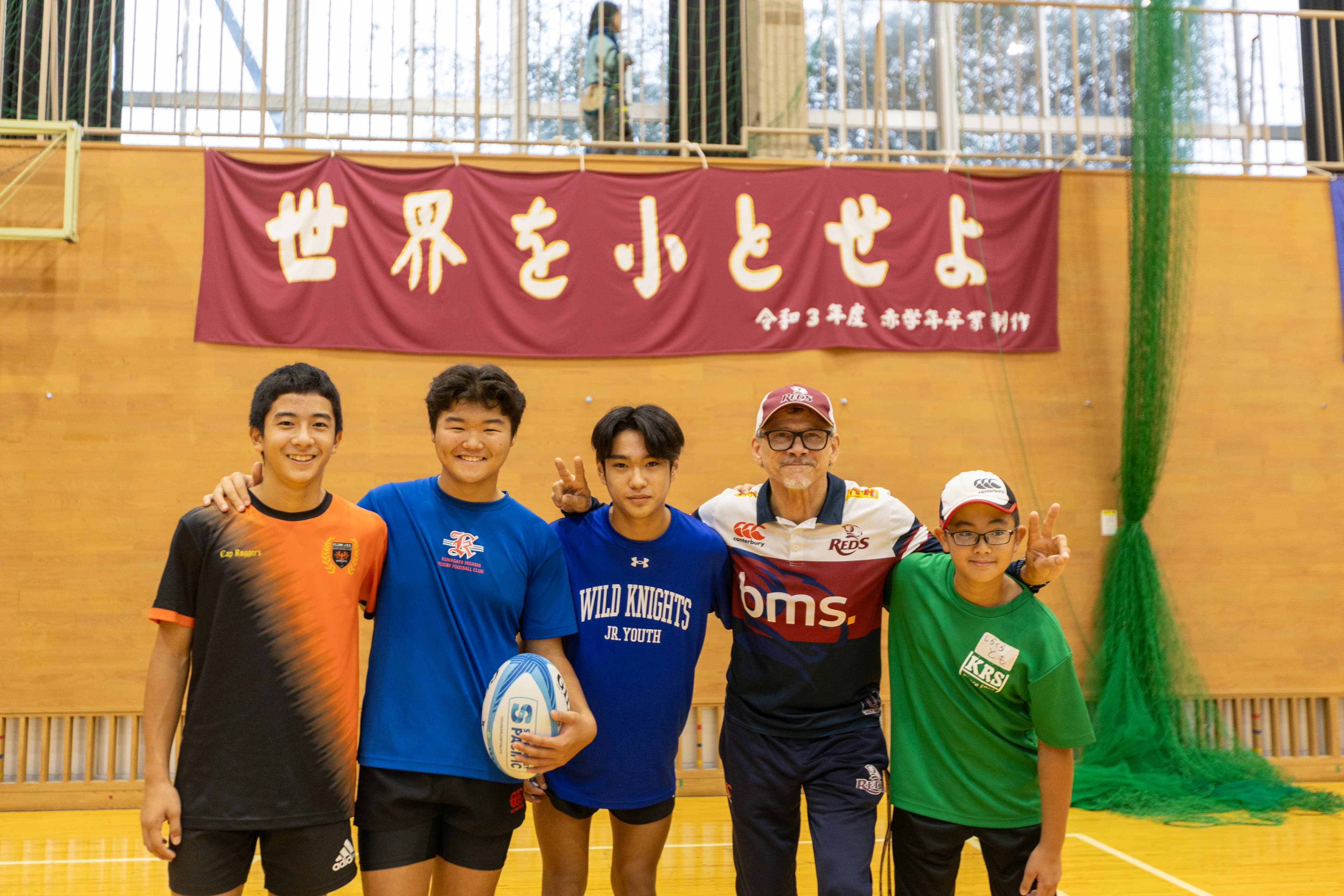 Reds coach Les Kiss and eager juniors at Saturday's rugby clinic in Kumagaya